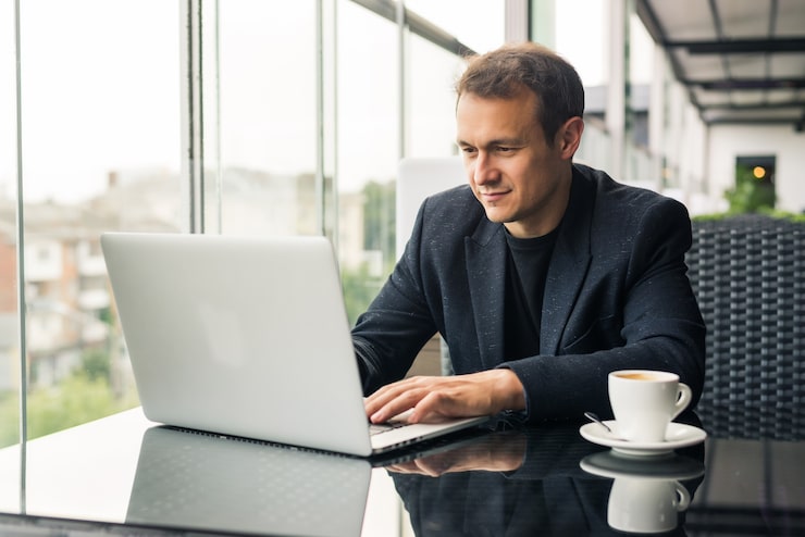 A professional working on a laptop in a bright modern cafe
